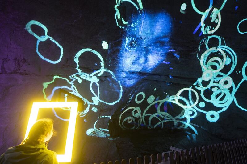 A visitor's face is projected on to a stone wall at the multi visual show Light Ragaz in the Tamina canyon in Bad Ragaz, Switzerland. EPA