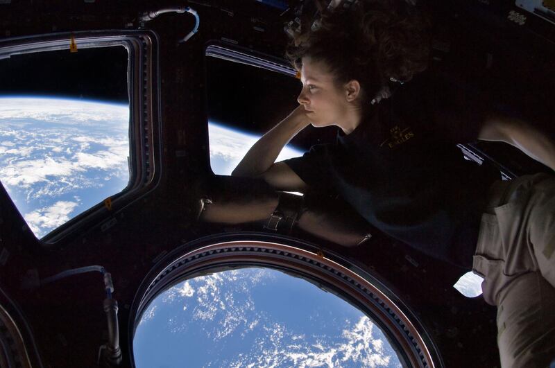 ISS024-E-014263 (11 Sept. 2010) --- NASA astronaut Tracy Caldwell Dyson, Expedition 24 flight engineer, looks through a window in the Cupola of the International Space Station. A blue and white part of Earth and the blackness of space are visible through the windows. 