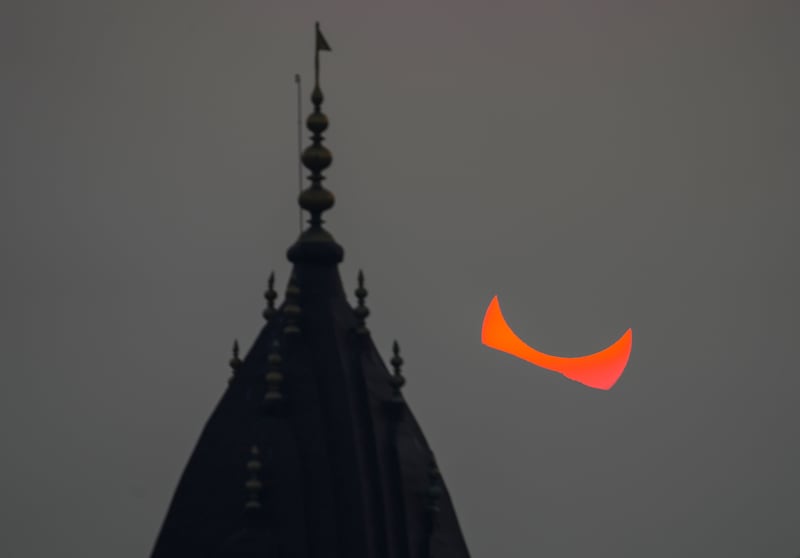 A partial solar eclipse behind the centuries-old Raghunath Hindu temple in Srinagar, Indian-controlled Kashmir. AP
