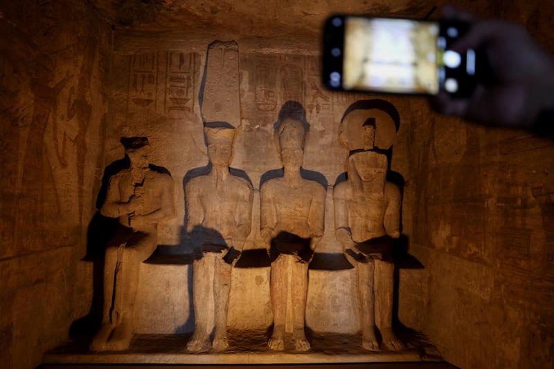 Statues of Pharaoh Ramses II, second right, and Amun, the god of light, second left, in the inner sanctum of the temple