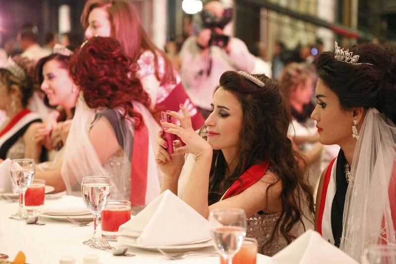 A newly wedded woman checks her mobile phone during a mass wedding of officers loyal to Syria’s president Bashar Al-Assad in hotel Dama Rose, Damascus, Syria. April 29, 2014. Omar Sanadiki / Reuters