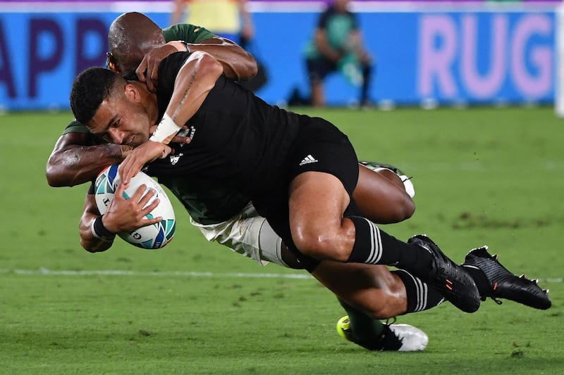 TOPSHOT - South Africa's wing Makazole Mapimpi (back) tackles New Zealand's fly-half Richie Mo'unga during the Japan 2019 Rugby World Cup Pool B match between New Zealand and South Africa at the International Stadium Yokohama in Yokohama on September 21, 2019. / AFP / Toshifumi KITAMURA
