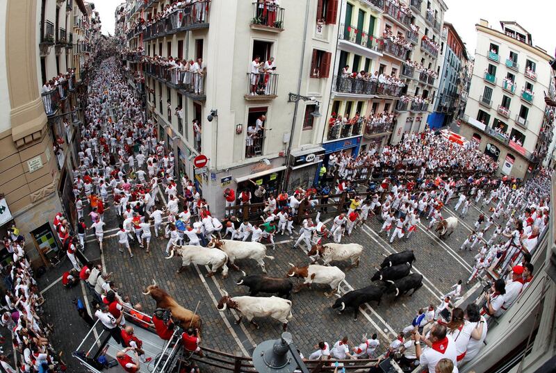 Runners triy to avoid bulls as they run down a street during the traditional San Fermin bull run in Pamplona, Spain. The festival, locally known as Sanfermines, is held annually from 06 to 14 July in commemoration of the city's patron saint. EPA