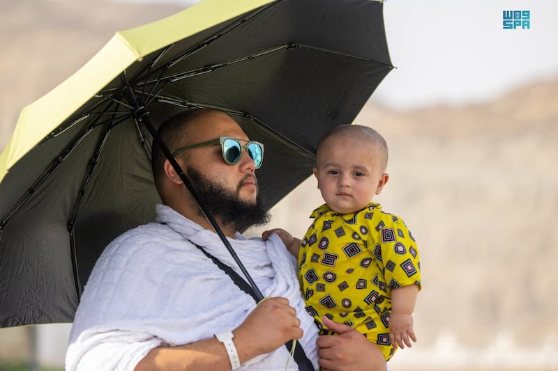 A toddler takes refuge under an umbrella as the temperature hit 45°C during the Hajj season. SPA
