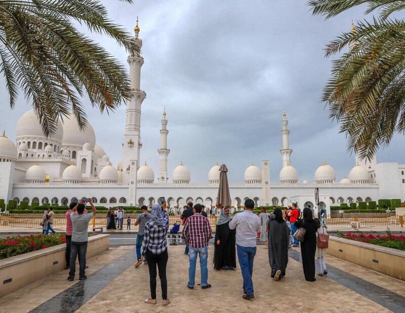 Abu Dhabi, United Arab Emirates, April 13, 2019.  Visitors enjoy the cool weather after a brief shower at the Sheikh Zayed Grand Mosque.
Victor Besa/The National.
Section:  NA 
Reporter: