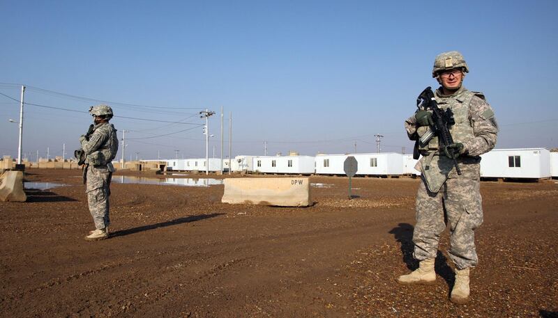 (FILES) In this file photo taken on December 29, 2014 US soldiers walk around at the Taji base complex which hosts Iraqi and US troops and is located thirty kilometres north of the capital Baghdad. Katyusha rockets targeted an Iraqi airbase north of Baghdad hosting US-led coalition forces, the Iraqi military said on January 14, 2020 in the latest attack on installations where American troops are deployed. The statement from Iraq's military did not say how many rockets had hit Camp Taji but reported that there were no casualties. / AFP / ALI AL-SAADI
