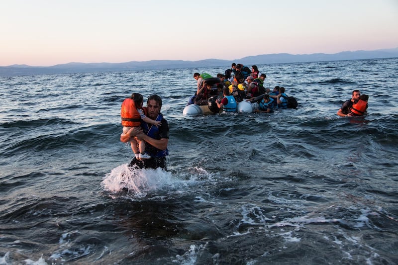 A group of Syrian refugees arrive on the island of Lesbos after travelling in an inflatable raft from Turkey, near Skala Sykaminias, Greece. *** Local Caption ***  RF121324_High_res.jpg
