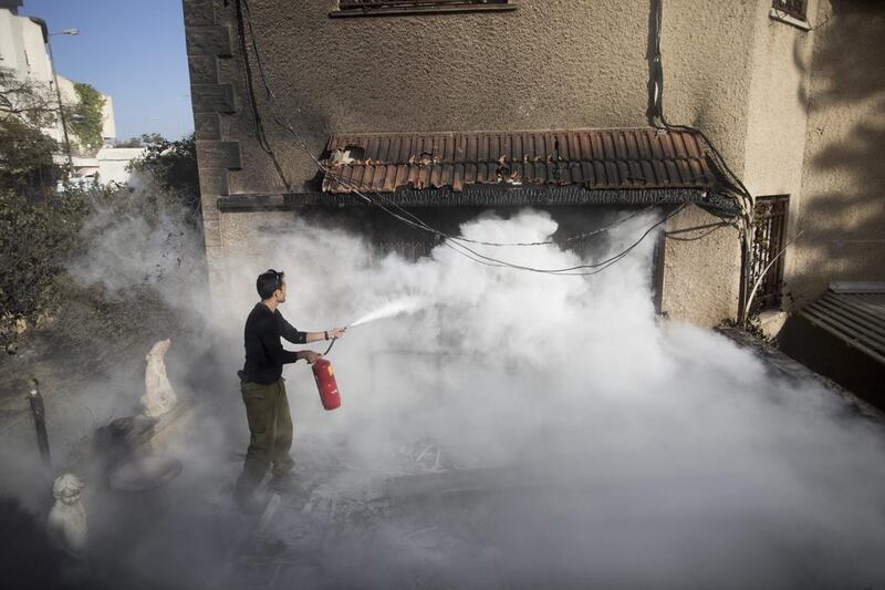 An Israeli soldier helps extinguish a fire next to a house in Haifa on November 25, 2016. Lior Mizrahi / Getty Images)