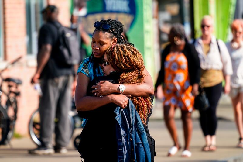 People embrace near the scene of the fatal mass shooting in Buffalo. AP