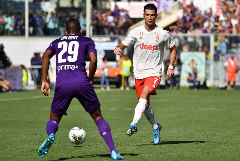 Juventus' Portuguese forward Cristiano Ronaldo passes the ball after being confronted by Fiorentina's Brazilian defender Dalbert. AFP