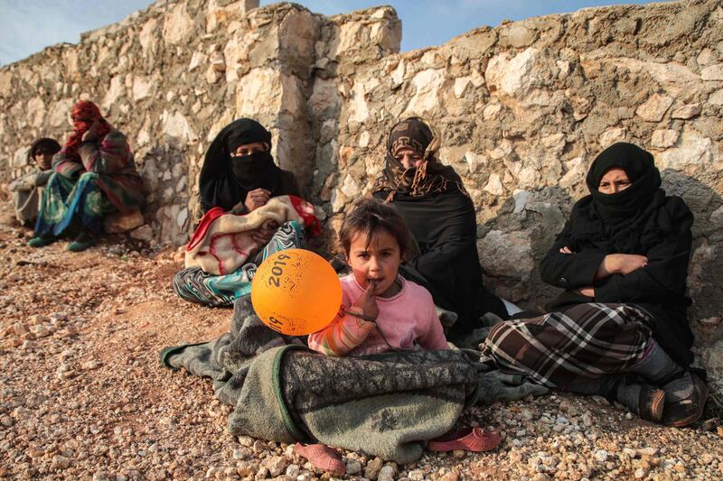 Displaced Syrians from the south of Idlib province sit out in the open in the countryside west of the town of Dana in the northwestern Syrian region.  AFP