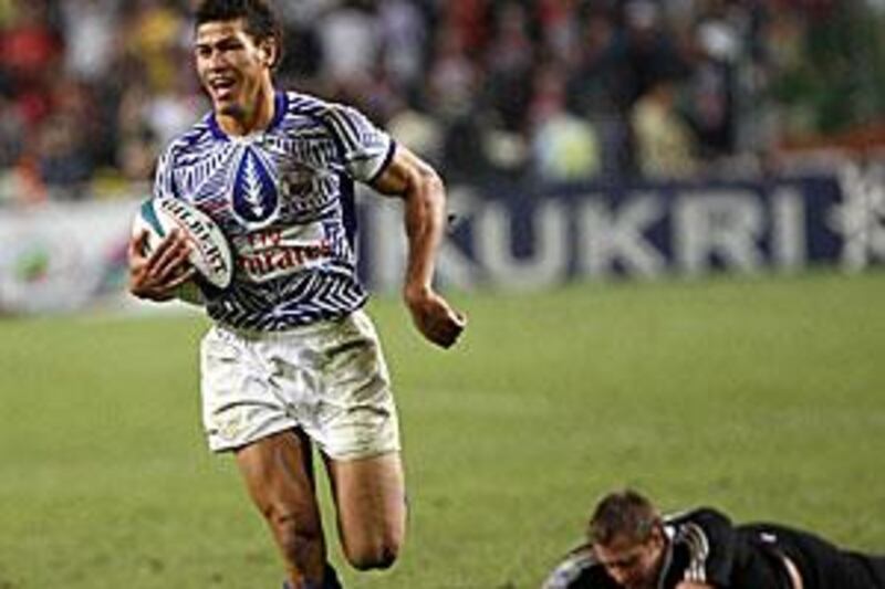 Samoa's Mikaele Pesamino, left, runs with the ball against New Zealand's Tim Mikkelson in the Hong Kong Sevens final.