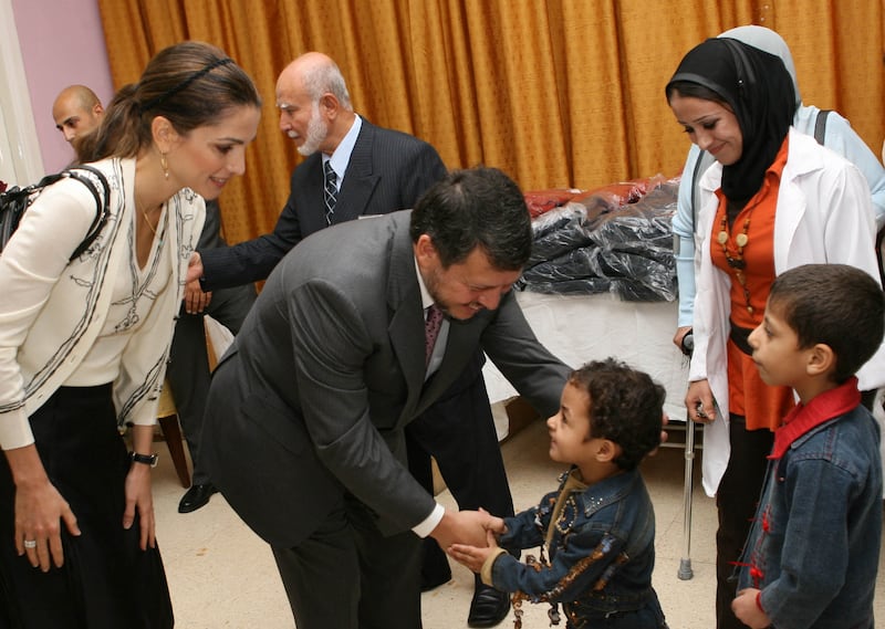 King Abdullah and Queen Rania wish children at an Amman orphanage a happy Ramadan in October 2006. AFP