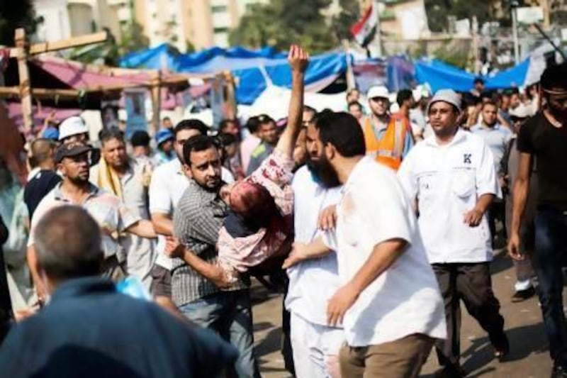 Supporters of Mohammed Morsi carry an injured man to a field hospital following clashes with security forces on Saturday morning. Manu Brabo / AP Photo