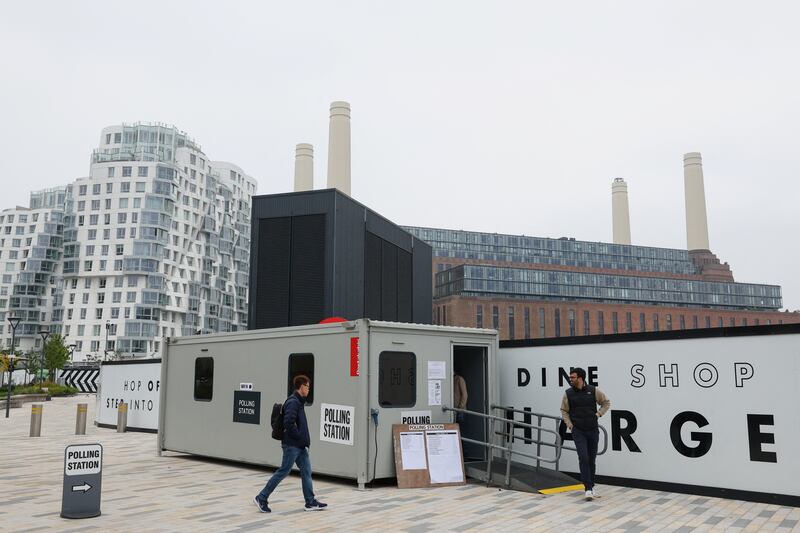 Voters arrive and leave a polling station beside Battersea Power Station in London. Reuters