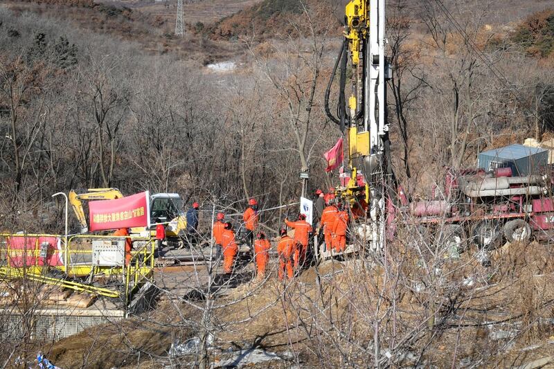 Members of a rescue team work at the site of a gold mine explosion where 22 miners are trapped underground in Qixia, in eastern China's Shandong province on January 18, 2021. At least 12 gold miners trapped hundreds of metres underground in China for more than a week have sent up a note warning that they are injured, surrounded by water and urgently need medicine. - China OUT
 / AFP / -
