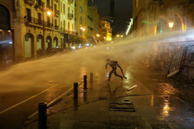 A demonstrator is hit by a water cannon during a protest against a ruling elite accused of steering Lebanon towards economic crisis in Beirut, Lebanon January 19, 2020. REUTERS/Aziz Taher