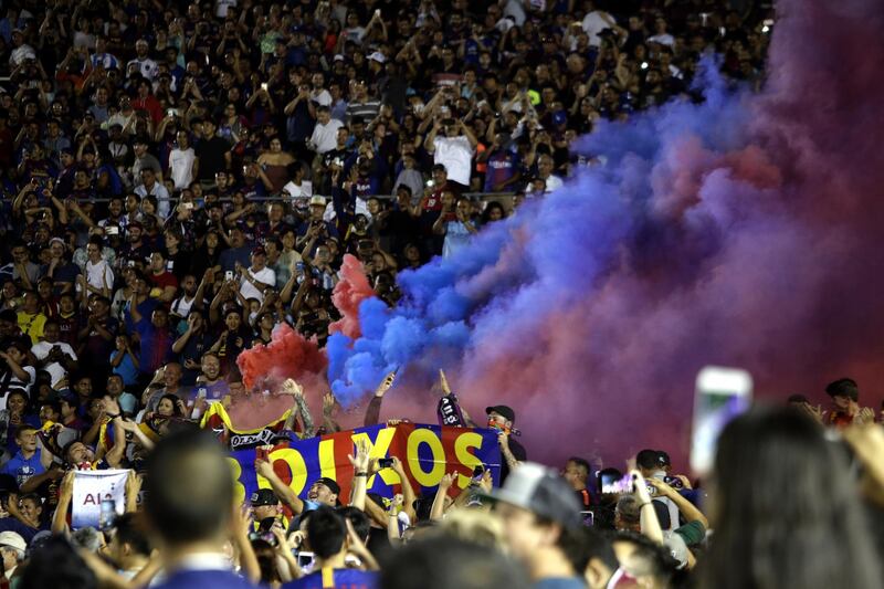 A coloured smoke bomb is set off among the Barcelona fans. EPA