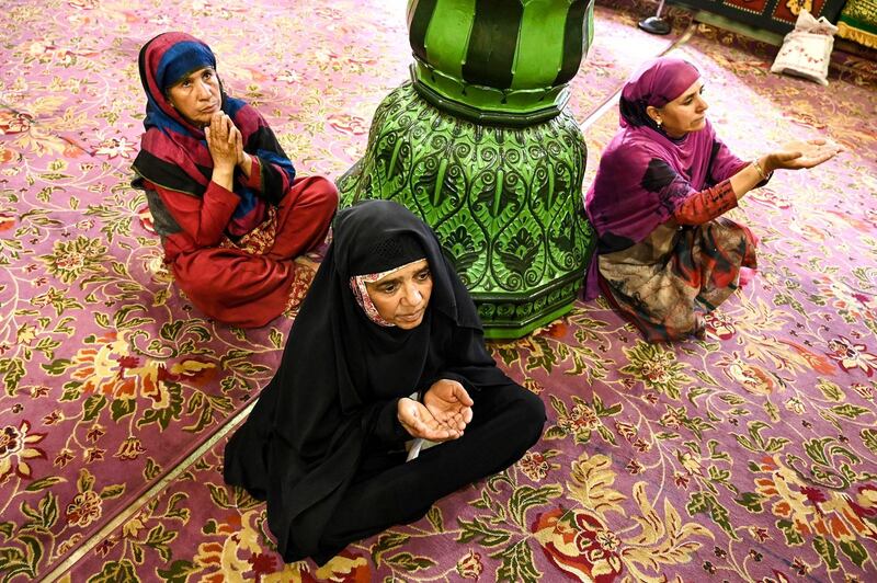 Kashmiri Muslims gesture as they pray at the Sheikh Abdul Qadir Geelani Shrine during the holy month of Ramadan in Srinagar.   AFP