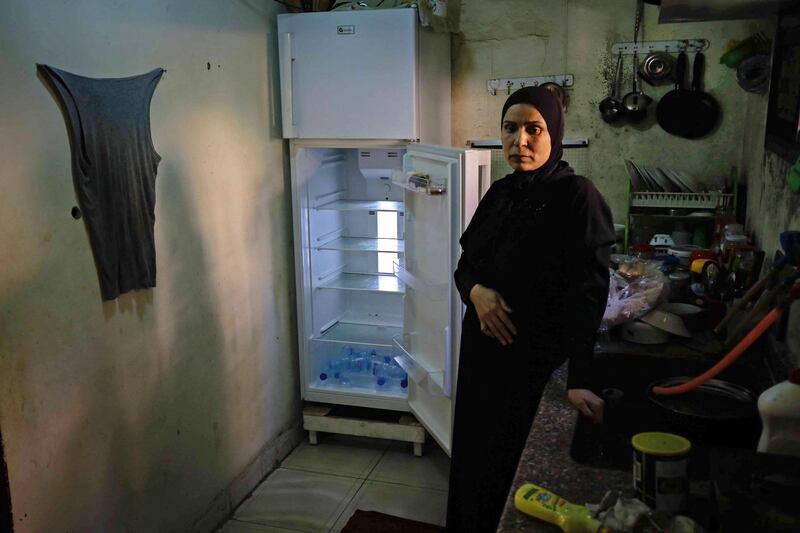 A Lebanese woman stands next to her empty refrigerator in her apartment in the port city of Tripoli. AFP