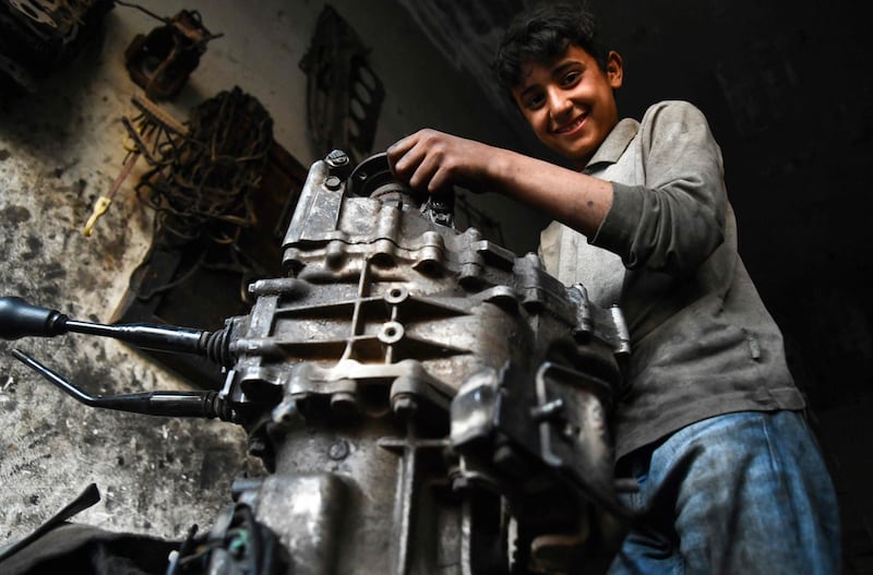 A young Syrian boy works at a car repair shop in the town of Jandaris, in the countryside of the north-western city of Afrin in the rebel-held part of Aleppo province, a day before the annual World Day Against Child Labour.