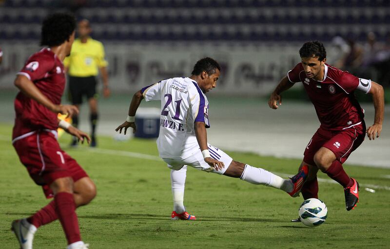 AL AIN , UNITED ARAB EMIRATES Ð Oct 14 : Tawfeeq Al Hosani ( no 2 in maroon ) of Al Wahda and Fawzi Fayez ( no 21 in white ) of Al Ain in action during the Etisalat Cup round 3 football match between Al Wahda vs Al Ain at Tahnoun Bin Mohammed Stadium in Al Ain. ( Pawan Singh / The National ) For Sports. Story by Amit
