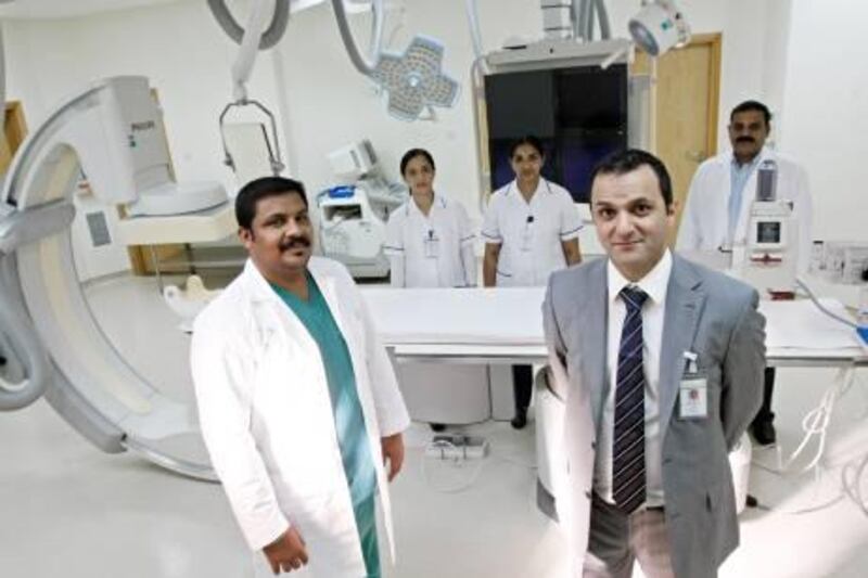 Dubai December 21, 2011 - From left, members of Rashid Hospital's MRI Intervention Radiology team, Senior Radiographer John Moses, Staff Nurses Meddy Melody and Suja George, Director of Intervention Radiology Dr. Ayman Al Sibaie and Senior Radiographer Rasik Ahmed in the Hybrid Vascular Catheter Lab at Rashid Hospital in Dubai, December 21, 2011. (Photo by Jeff Topping/The National) 
