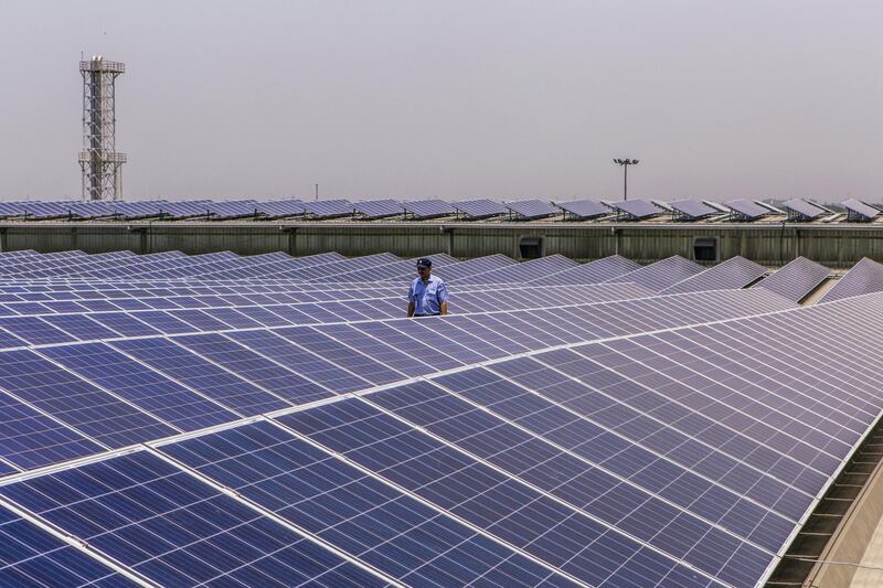 A security guard walks past solar panels implemented by Amplus Solar on the roof of the Yamaha Motor Co. plant in Surajpur, Uttar Pradesh, India, on Wednesday, July 20, 2016. The Japanese motorcycle maker wants solar power to supply a quarter of energy needs at its northern Indian factories near Delhi, according to company executives. Photographer: Prashanth Vishwanathan/Bloomberg