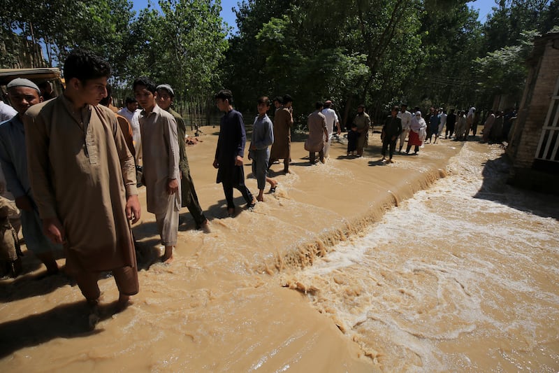 People wade through a flooded area following heavy rains in Charsadda District, Khyber Pakhtunkhwa province, Pakistan. EPA