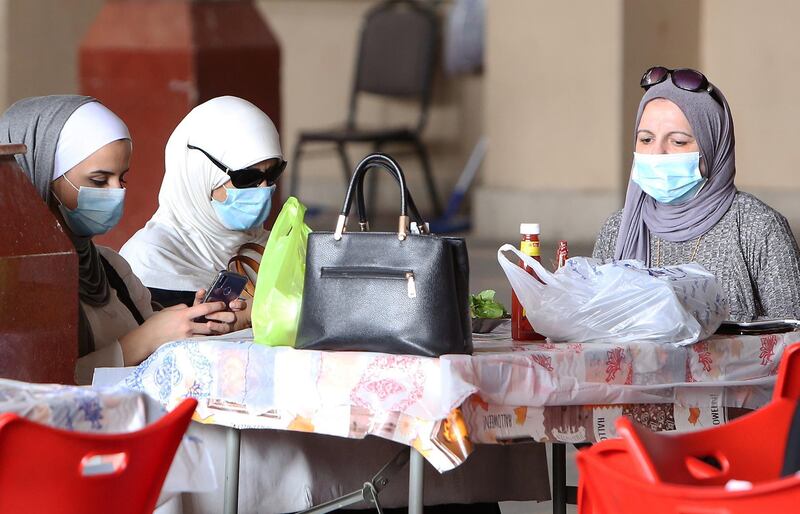 Kuwaiti women wear protective masks as they sit in a restaurant inside the Mubarakiya Market in Kuwait City.  AFP