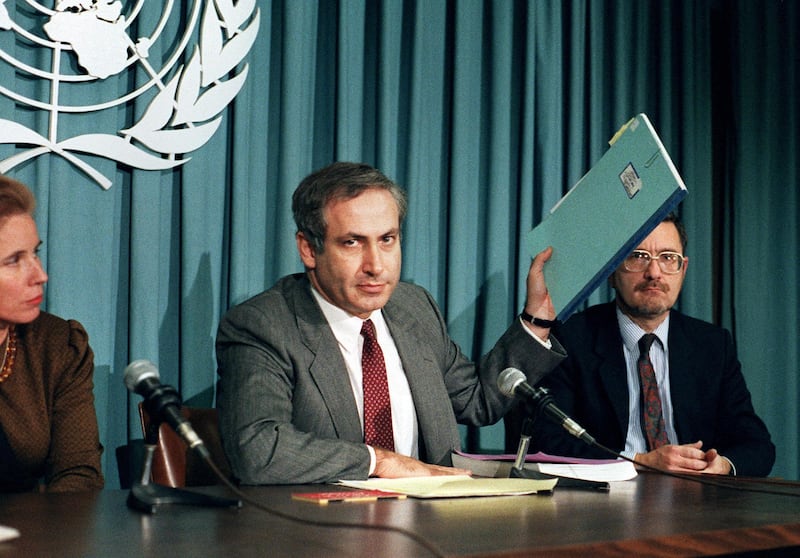 Israeli Permanent Representative to the United Nations Ambassador Benjamin Netanyahu holds up a file on Nazi criminal Alois Brunner at a news conference at the U.N. 6 November 1987. Netanyahu was discussing the opening of the U.N. Nazi War Crimes Archives. (Photo by DON EMMERT / AFP)