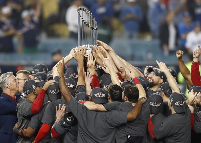 Boston Red Sox players celebrate with the Commissioner's Trophy. EPA