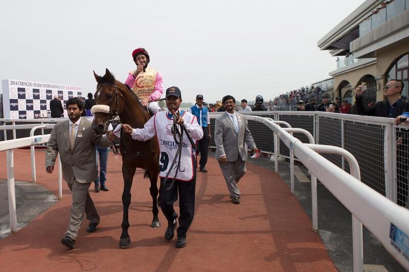 Royston Ffrench signals all is well after guiding Mutual Force to victory lane in the Chengdu Dubai International Cup race at Jinma Racecourse on April 6, 2014 in Chengdu, China.  Neville Hopwood / Getty Images