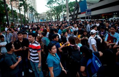 Employees are seen at an open area in Manila, after an earthquake rocked the Philippines on April 22, 2019. A powerful earthquake rocked the Philippines, sending thousands of people fleeing high-rises in Manila as buildings shook. Office workers piled out onto the streets as emergency alarms blared, AFP reporters saw, but there were no immediate reports of injuries or damage. / AFP / Noel CELIS
