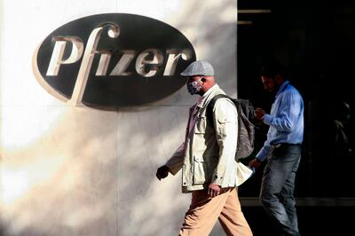 TOPSHOT - People walk by the Pfizer world headquarters in New York on November 9, 2020.  Pfizer stock surged higher on November 9, 2020 prior to the opening of Wall Street trading after the company announced its vaccine is "90 percent effective" against Covid-19 infections. The news cheered markets worldwide, especially as coronavirus cases are spiking, forcing millions of people back into lockdown. / AFP / Kena Betancur
