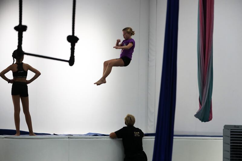 Students practise high jumps on a trampoline