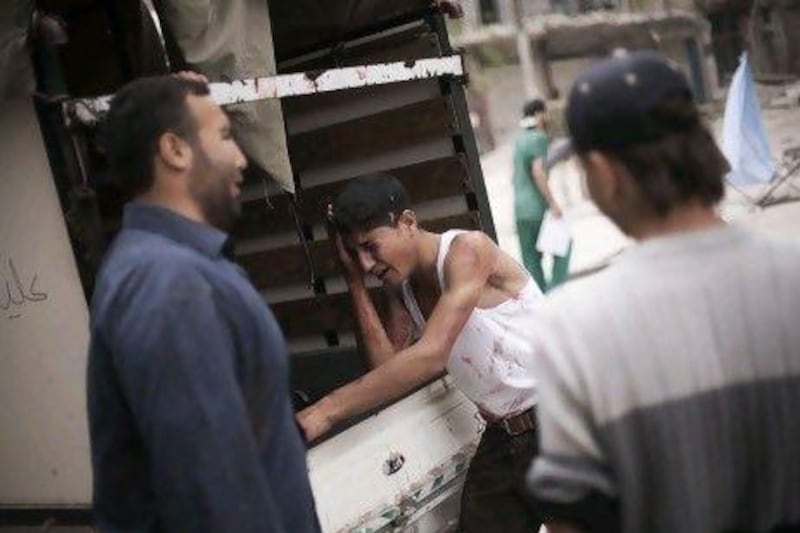 A Syrian youth cries next to a truck holding the body of his brother, killed by Syrian Army shelling, outside Dar Al Shifa hospital in Aleppo. Members of staff at the rebels’ field hospital say about 80 per cent of the 100 or so people treated daily are civilians.