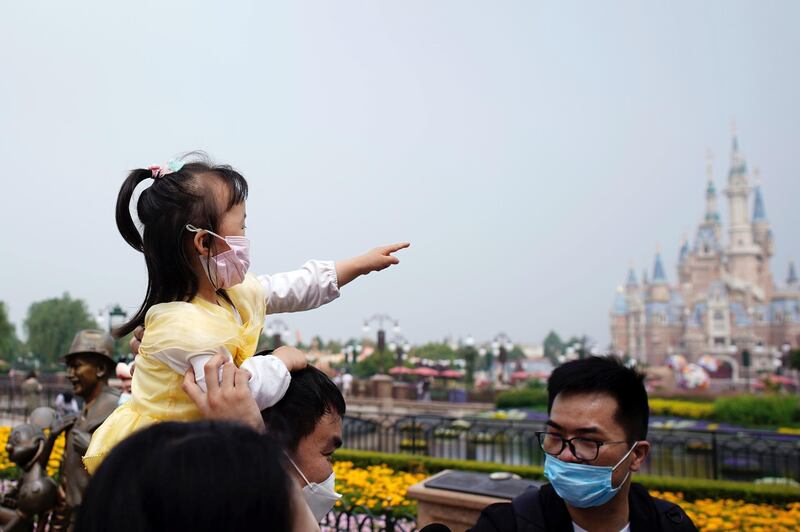 Visitors wearing face masks explore Shanghai Disneyland. Reuters