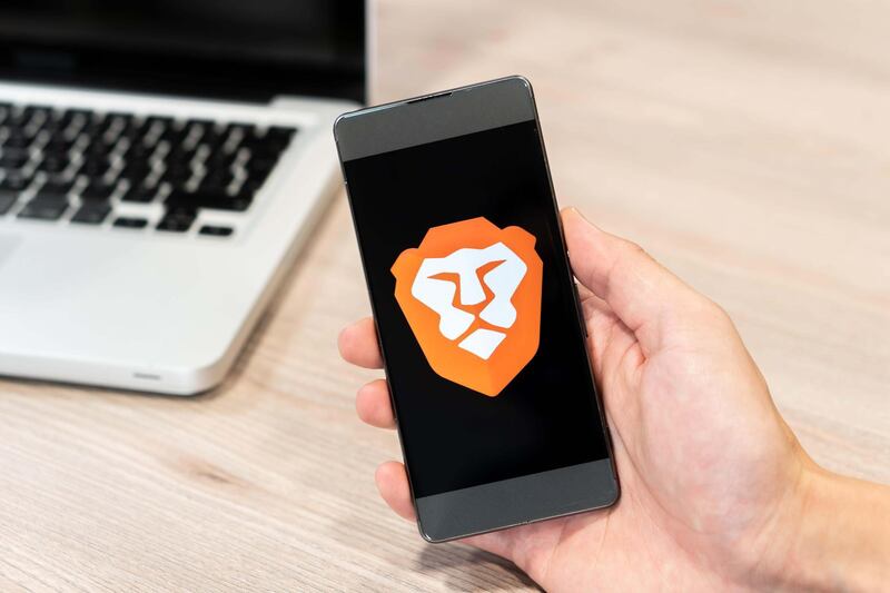 RMGYGX Brave Browser logo displayed on smartphone and computer laptop in background. Slovenia 13.02.2019. Alamy