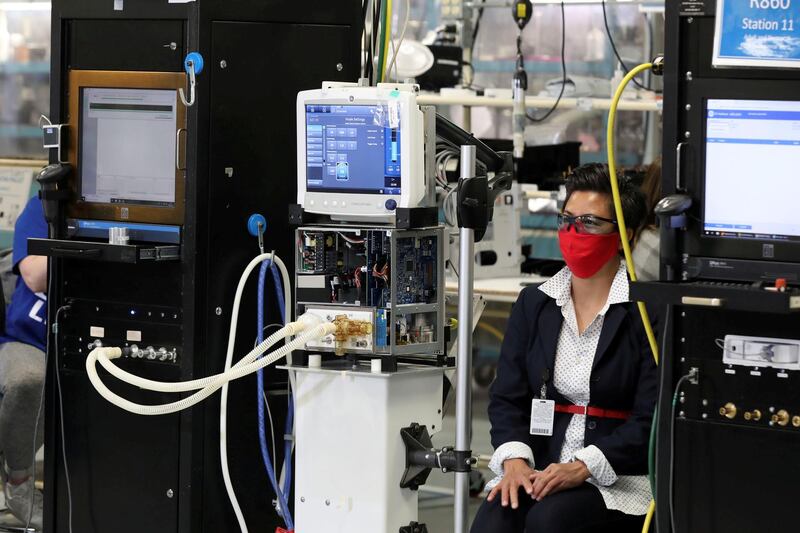 An employee wearing a face mask sits next to a GE Carescape R860 ventilator in an assembly and testing area at a GE Healthcare manufacturing facility during the global coronavirus disease (COVID-19) outbreak in Madison, Wisconsin, U.S.  REUTERS