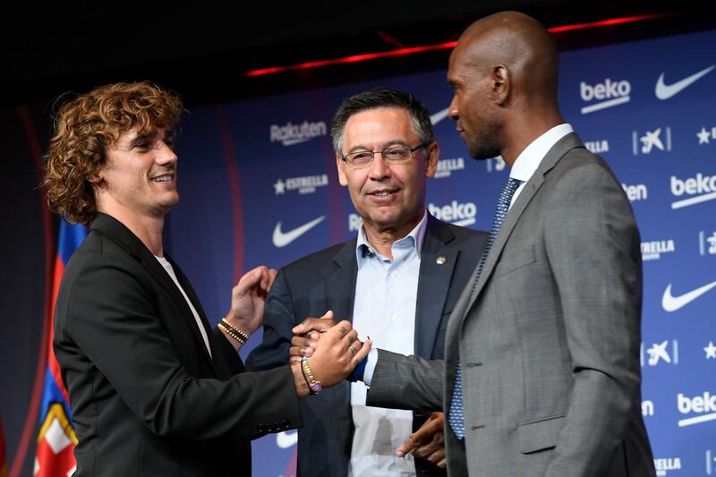 Barcelona's new French forward Antoine Griezmannshakes hands with the club's president Josep Maria Bartomeu and football director Eric Abidal, right. AFP