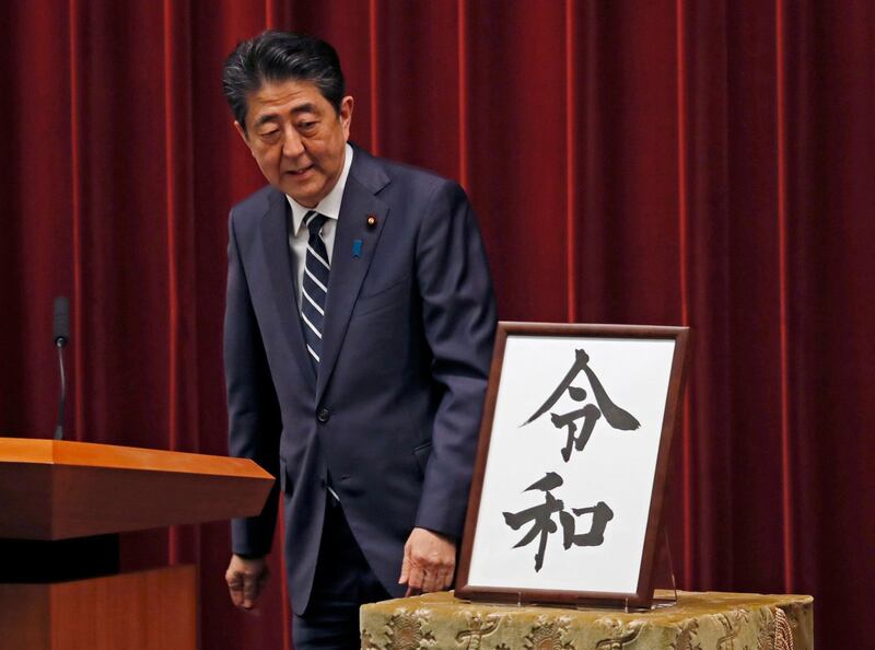 Japanese Prime Minister Shinzo Abe looks at the name of new era "Reiwa" on display at the Prime Minister's office in Tokyo. AP