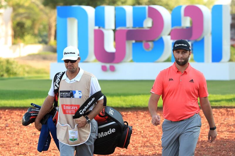 Jon Rahm with his caddie Adam Hayes walk up the 17th fairway. Getty