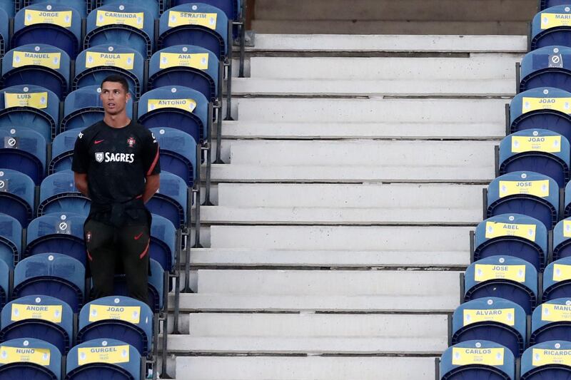 Portugal's Cristiano Ronaldo takes a seat on the stands without a mask. AP Photo