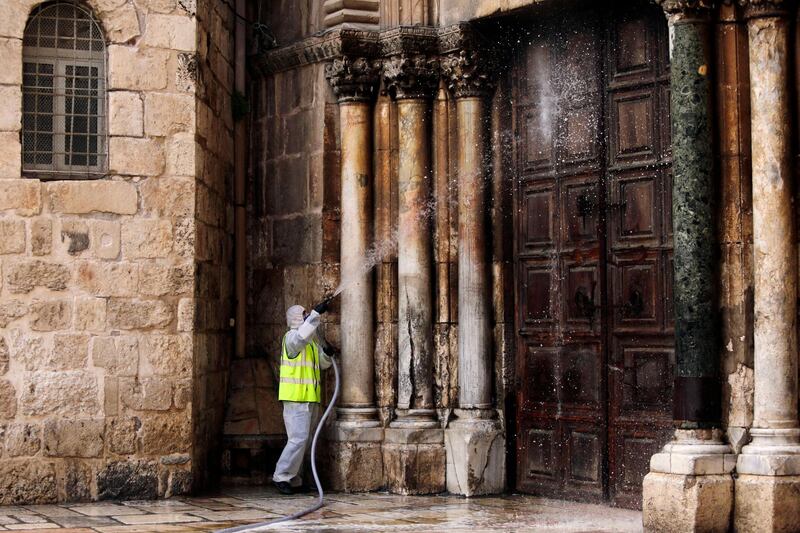 A worker disinfects the doors of the closed Church of the Holy Sepulchre in Jerusalem's Old City, as general public movements are limited to prevent the spread of coronavirus. AP Photo