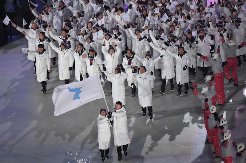 Unified Korea's flagbearers (North Korea's ice hockey player) Hwang Chung Gum and (South Korea's bobsledder) Won Yun-jong (front R) lead the Unified Korea delegation during the opening ceremony of the Pyeongchang 2018 Winter Olympic Games at the Pyeongchang Stadium on February 9, 2018. / AFP PHOTO / LOIC VENANCE