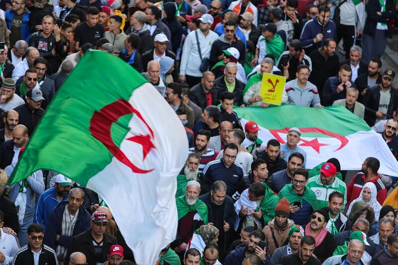Demonstrators carry national flags during a protest to demand that a presidential election next month be cancelled until the old ruling guard step aside and the army quit politics, in Algiers, Algeria. Reuters