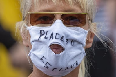 epa08607020 A demonstrator wearing a face mask with a hole showing her mouth takes part in a protest against health measures made by the Belgian government over the coronavirus disease (COVID-19) pandemic, in Brussels, Belgium, 16 August 2020. The group of demonstrators does not deny the existence of the coronavirus but disputes its degree of contagiousness and its lethality and does not want to wear masks.  EPA/JULIEN WARNAND