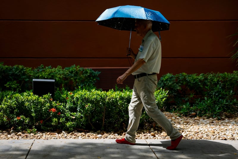 A pedestrian carries an umbrella during a heat wave in Miami, Florida, US. Bloomberg