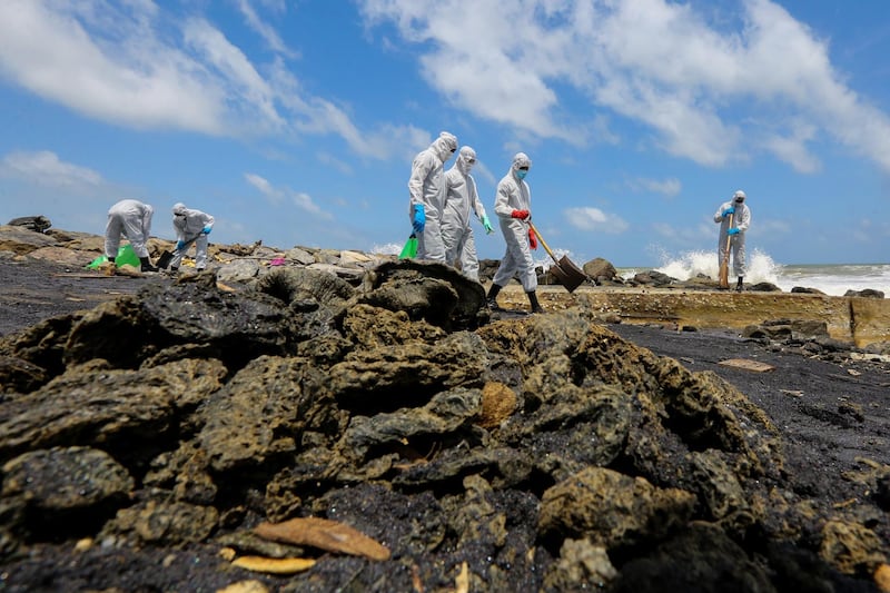 Sri Lanka Air Force personnel wearing protective clothing clear the beach from debris and other materials. EPA